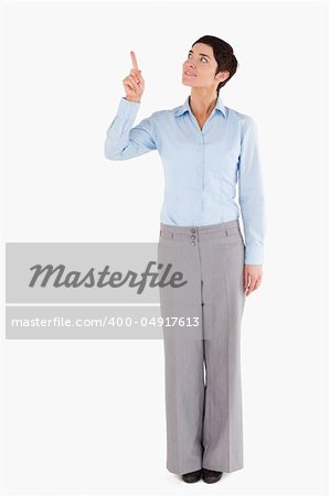 Businesswoman pointing at copy space against a white background