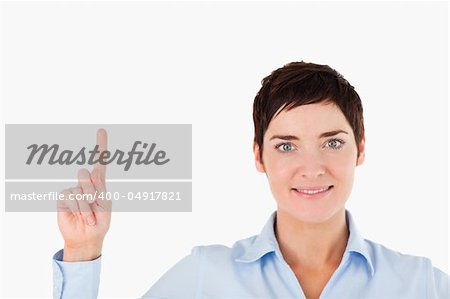 Close up of a woman pointing at copy space against a white background