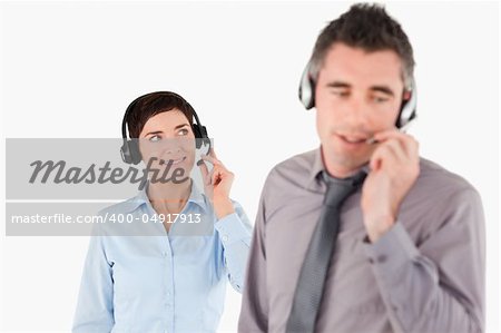 Business people speaking through headsets against a white background