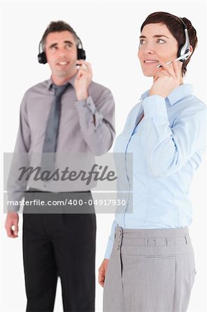 Portrait of colleagues using headsets against a white background
