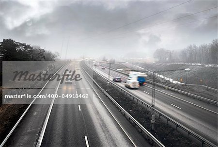 Traffic on highway on a foggy rainy day