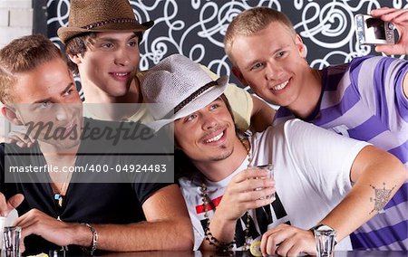 Self portrait of handsome bunch of guys drinking and enjoying in nighclub.