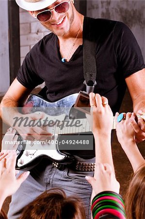 Rock guitarist playing in front of a cheering crowd.