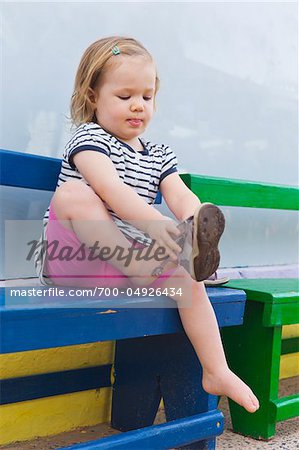 Little Girl Putting on Shoe
