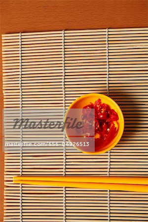 Small bowl of red chillies and chopsticks.