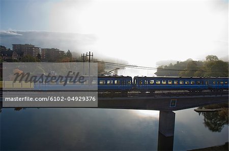 Train on bridge by lake