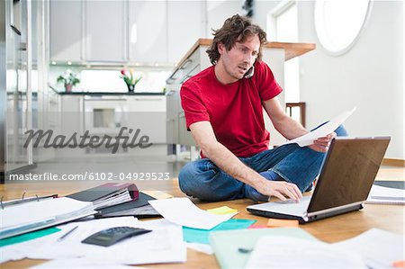 Mid- adult man struggling with domestic paperwork