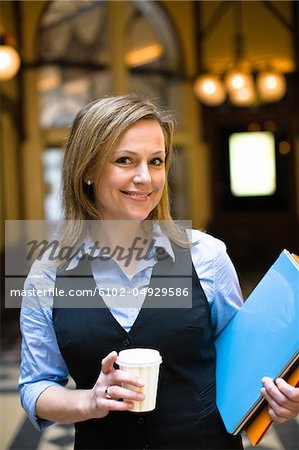Portrait de femme d'affaires Mid holding café file et takaway