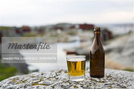 Bouteille de bière et de verre sur le rocher