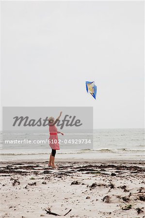 Woman flying kite at beach