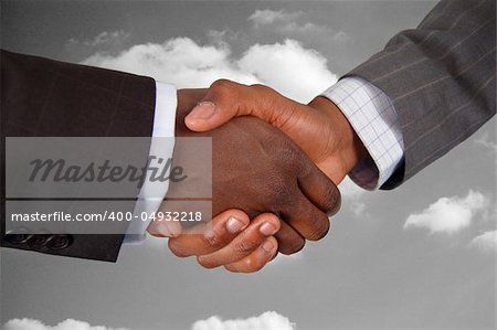 This is an image of two business hands performing a handshake, with a cloud background.