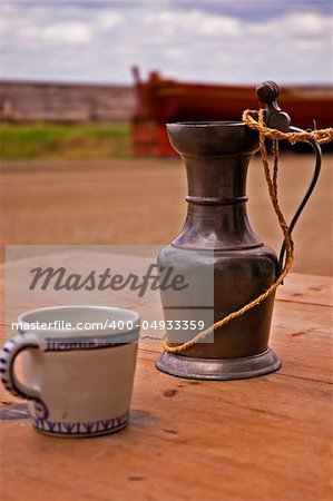 A cup and gauntlet sitting on a table in the streets of Louisbourg