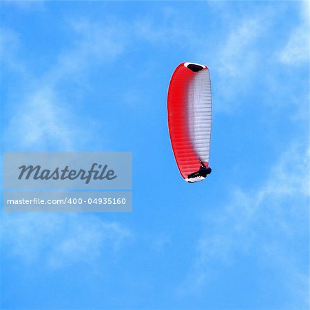 man, hovering in the sky by parachute