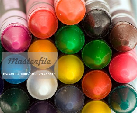 Multi coloured crayons against a plain background