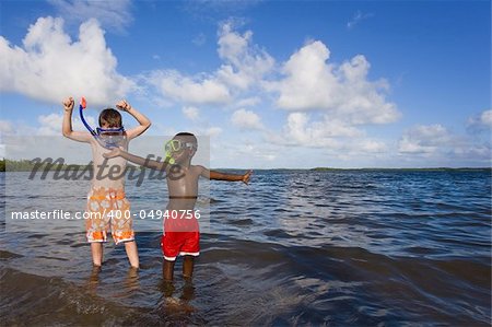 Two young boys playing with snorkel gear in the water - one Caucasian, one African American. John Pennecamp Park, Florida Keys.
