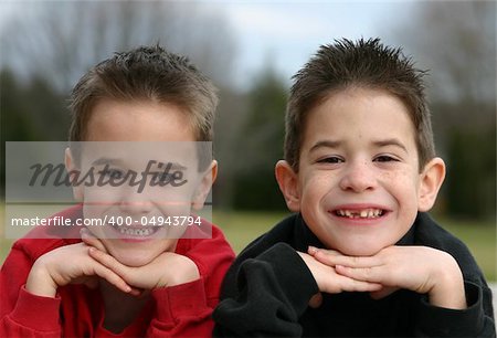 Two brothers smiling with chin in hands