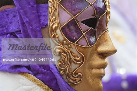 Venetian mask decorated with gold leaf and rich velvet cloth.
