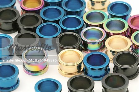 A big pile of colorful titanium screw on flesh tunnels. These are used in stretched ear lobes.