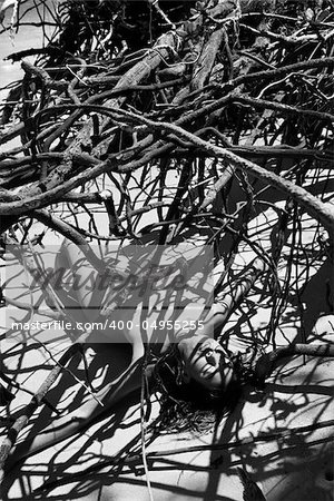 Pretty Filipino nude young woman on beach in tree shadows in Maui, Hawaii.