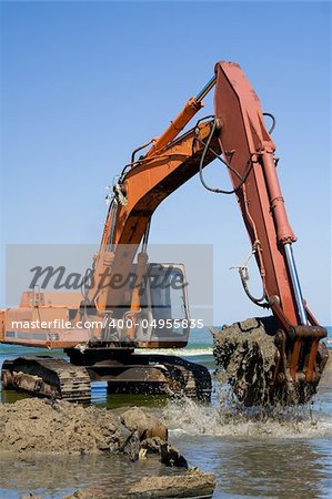 Orange Excavator on the beach