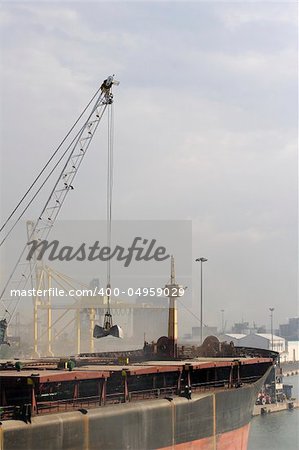 freight ship being loaded with aggregate on dockside