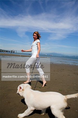 woman running with her dog on the beach