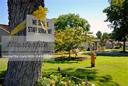 Sign and yellow ribbon on a tree trunk honoring a soldier serving in the Iraq War