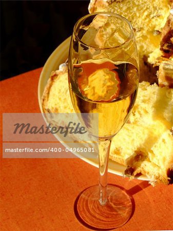 An italian Christmas table with glass of spumante and panettone