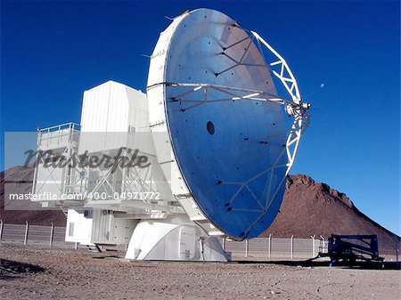 Radio telescope at a high alititude site with moon in background.