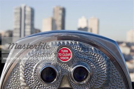 A set of tourist binoculars looks towards a dense part of San Francisco.