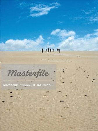 Group of people walking on sand dunes in Southern Australia.