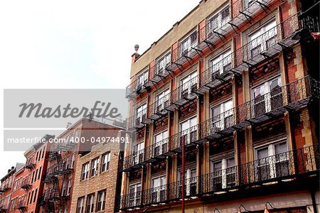 Row of brick houses in Boston historical North End with wrought iron balconies and fire escapes