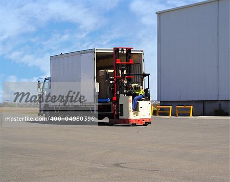 Forklift driver loading small truck