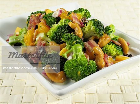 Broccoli salad with bacon, raisins, cashews, mandarin oranges, cheddar cheese, red onion, and a sweet mayonnaise dressing.