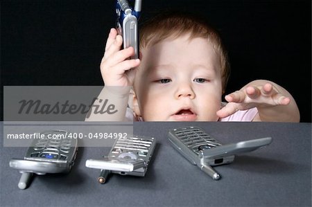 Child with mobile phones, isolated on a black background