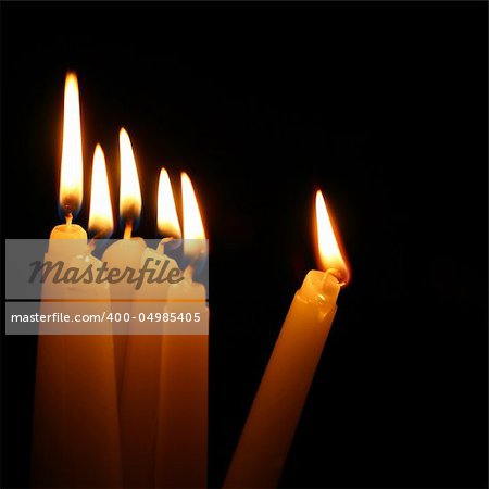 sacred candles in dark on black background