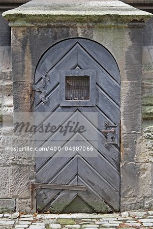 Alte Kirchentür mit einem Fenster auf Ebene der Augen.