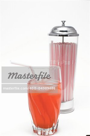 A glass of carbonated cherry soda with a drinking straw.