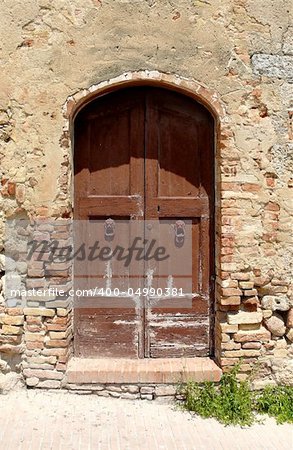 Antique door in brick wall, Italy