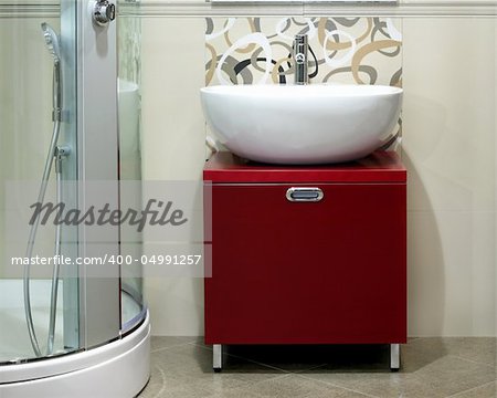 Modern round white basin over red cabinet