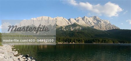 The summits of Zugspitze (right, 2963m) and the Waxensteine (left, 2277m) in the german Alps near Garmisch-Partenkirchen. In the foreground the beautiful lake Eibsee.