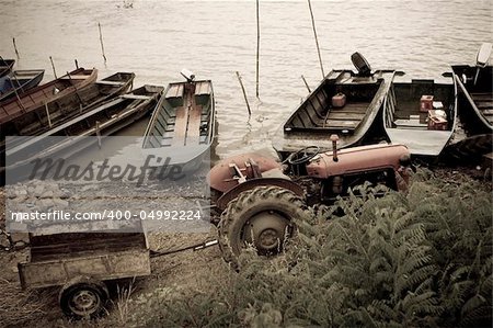 vintage tractor and traditional fishing boats on the river Danube