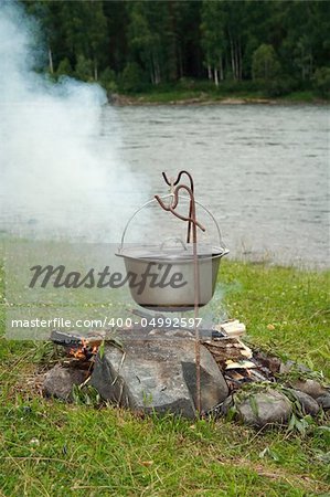 kettle on a burning fire near the river