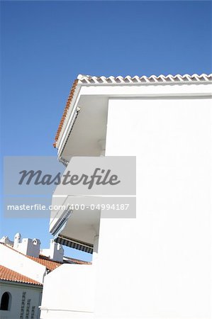 white washed apartment block against a blue sky