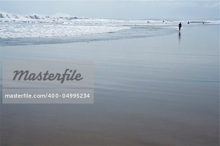 woman silhouetted walking on kuta beach bali at low tide