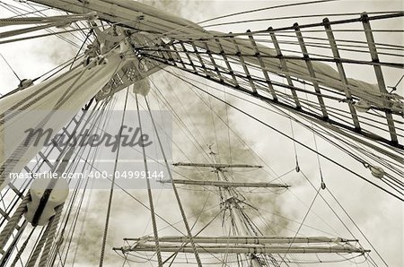 Masts of a sailing vessel with curtailed sails.