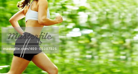 Beautiful young woman runner in a green forest.