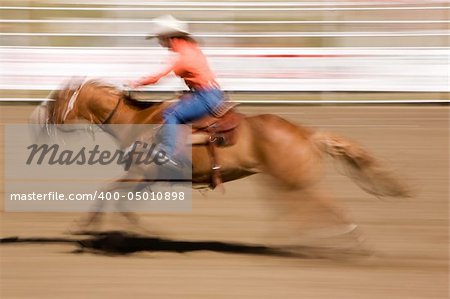 A horse galloping fast with a female rider -  motion blur.