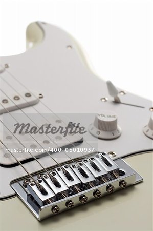 Close portrait view of the bridge and body of a white electric guitar. Isolated on white.