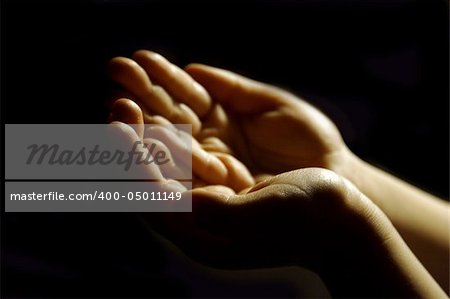 Worshiping hands pray on black background